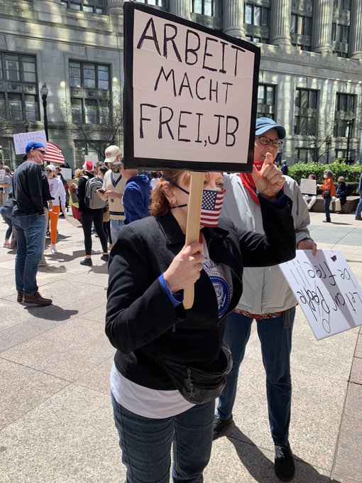 Imaginea articolului Fotografia cu femeia care a folosit sloganul nazist „Arbeit macht frei” de la Auschwitz ca mesaj de protest faţă de şomaj, virală
