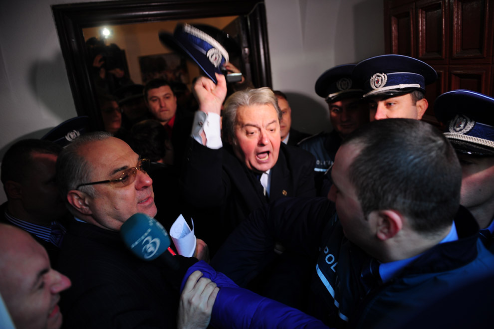 Liderul PRM, Corneliu Vadim Tudor (C), ameniţă un poliţist, în sediul PRM din Bucureşti, marţi, 4 ianuarie, 2011. (Octav Ganea / Mediafax Foto)