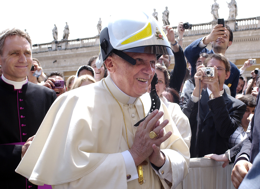 Papa Benedict al XVI-lea poartă o cască de pompier primită cadou la sfârşitul audienţei sale generale din piaţa Sfântul Petru, în Vatican, miercuri, 15 iunie 2005. 
