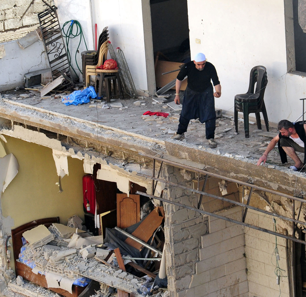 O fotografie primită de la Agenţia de Ştiri Arabo Siriană (SANA) îi arată pe locatarii unui bloc din Damasc inspectând pagubele provocate de o explozie, luni 29 octombrie 2012. (AFP / SANA)