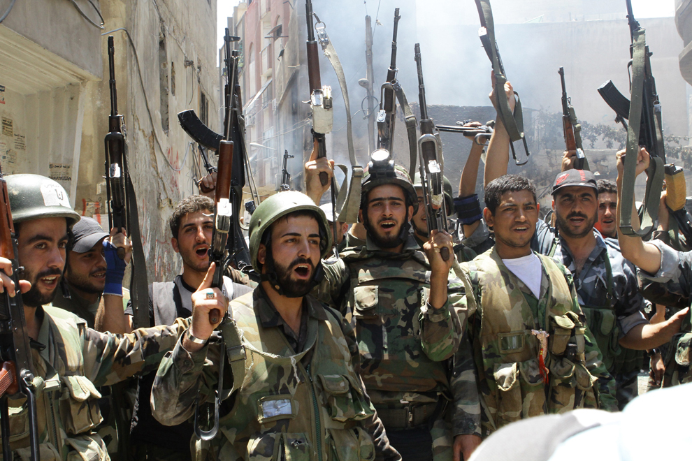 Soldaţi sirieni, care ar fi respins rebelii din zona al-Midan a Damascului, sărbătoresc, vineri, 20 iulie, 2012. (Louai Beshara / AFP)
