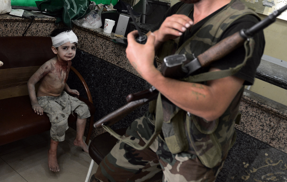 Un băiat sirian, rănit atunci când un obuz tras de către forţele guvernamentale a lovit casa sa, aşteaptă sa fie consultat de către un medic într-un spital din oraşul sirian Alep, vineri, 24 august 2012. (Aris Messinis / AFP)