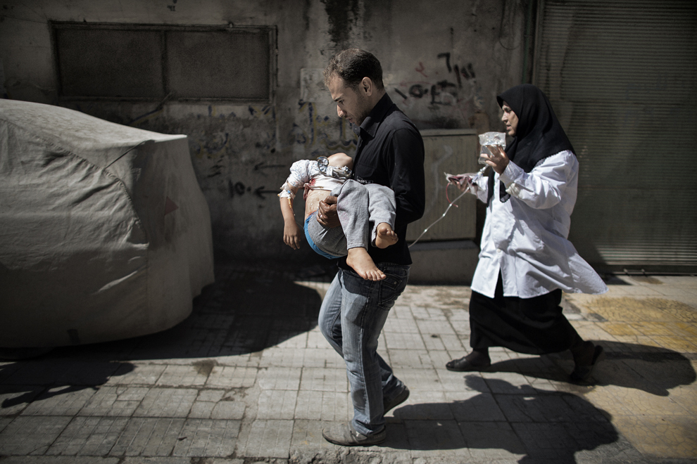 Un bărbat sirian îşi ţine in braţe fiica rănită, în afara unui spital din Alep, oraş afla in nordul Siriei, marţi, 18 septembrie 2012. (Marco Longari / AFP)
