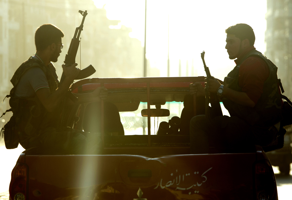 Rebeli sirieni ai brigăzii Al-Ansar patrulează pe o stradă din Alep, marţi, 25 septembrie 2012. (Miguel Medina / AFP)