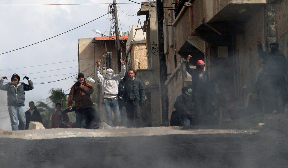 Protestatari antiguvernamentali gesticultează pe străzile oraşului Daraa, aflat la 100 de km sud de capitala Damasc, miercuri, 23 martie 2011. (Anwar Amro / AFP)