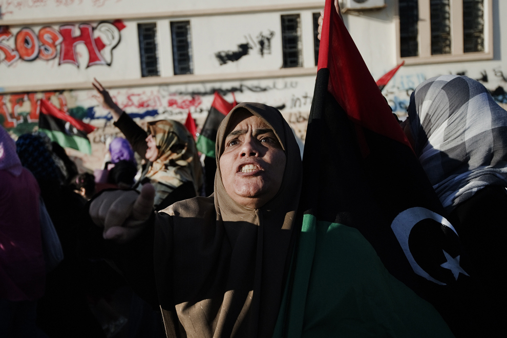 Aproape o sută de demonstranţi scandează lozinci împotriva liderului libian Muammar Al-Gaddafi şi în sprijinul revoltei împotriva preşedintelui sirian Bashar Al-Assad în timpul unui protest în Benghazi, marţi, 14 iunie 2011. (Gianluigi Guercia / AFP)