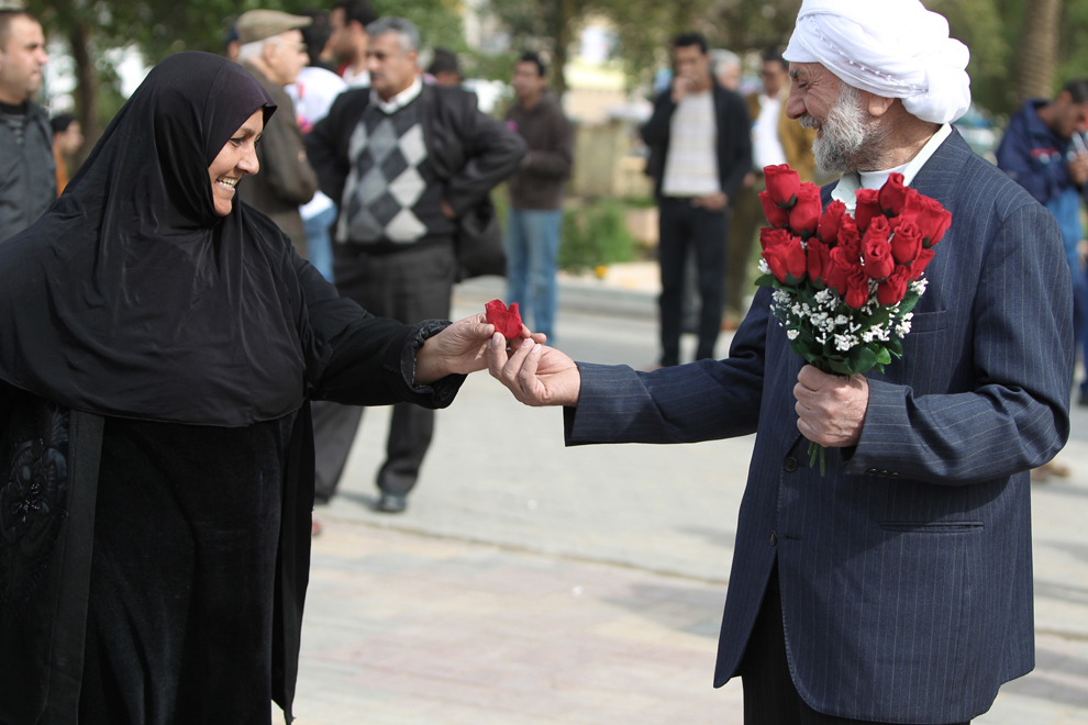 Un bărbat irakian oferă un trandafir unei femei, cu ocazia Valentine’s Day, în piaţa Tahrir din Bagdad, joi, 14 februarie 2013.  