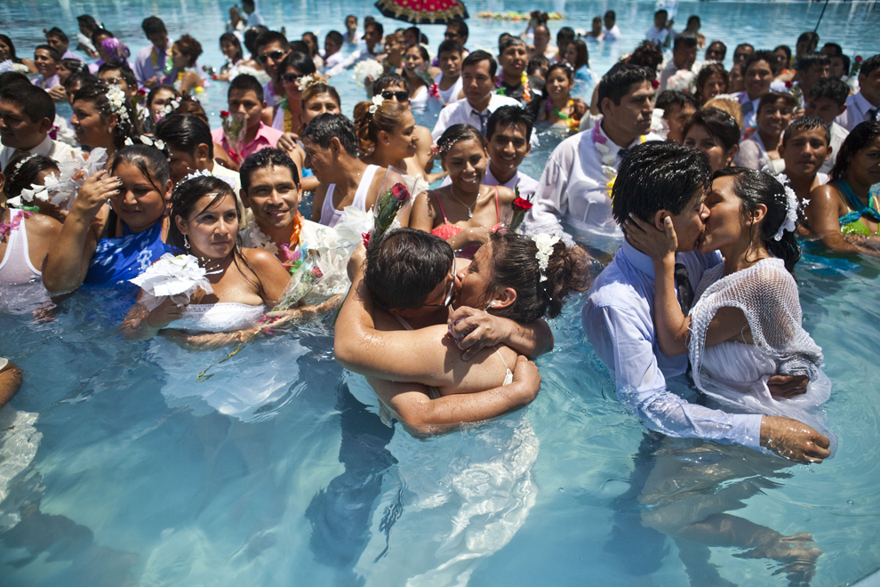 Mai multe cupluri se sărută într-o piscina, în timpul unei căsătorii civile comune, cu ocazia Valentine’s Day, în Lima, Peru, joi, 14 februarie 2013. 
