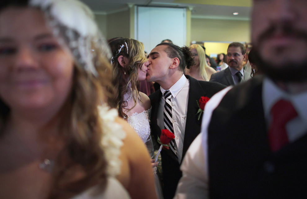 Brianna şi Matias Astudillo se sărută după ce s-au căsătorit, în timpul unei ceremonii în care 40 de cupluri s-au căsătorit, în West Palm Beach, Florida, joi, 14 februarie 2013. 