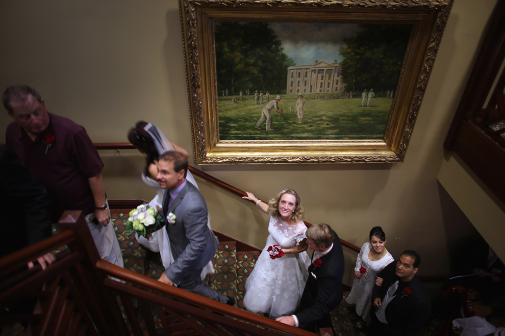 Mirese şi miri urcă pe scari pentru a fi căsătoriţi, în cadrul unei ceremonii la care 40 de cupluri s-au unit, în West Palm Beach, Florida, joi, 14 februarie 2013. 