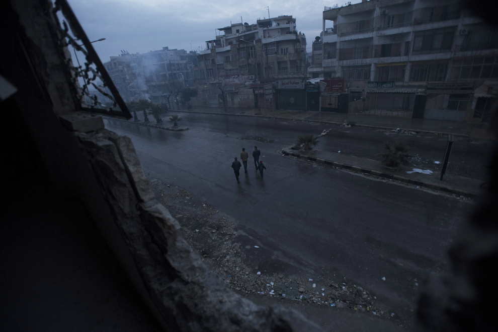 Mai mulţi sirieni merg pe o stradă din Alep, după rugăciunea de seară, care a avut loc în moschea al-Nasr, duminică, 6 ianuarie 2013. 