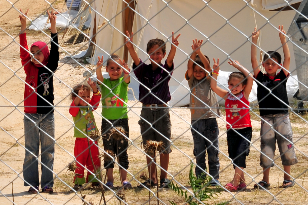 Copii refugiaţi sirieni arătă către cameră semnul V, în tabăra de refugiaţi Boynuyogun a Semilunii Roşii Turce, din districtul Altinozu al provinciei Hatay, în apropierea graniţei cu Siria, luni, 11 iunie 2012. (Mustafa Ozer / AFP)