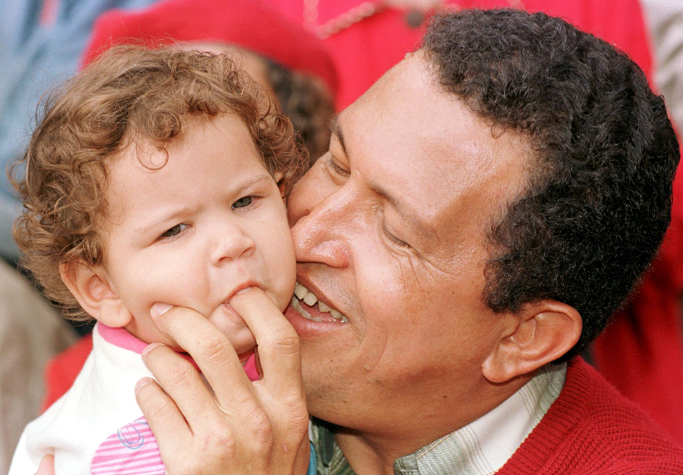 Candidatul la funcţia de preşedinte al Venezuelei, Hugo Chavez Frias se joacă cu fetiţa lui în vârstă de un an, Rosaines, în timpul unui miting electoral, în Caracas, sâmbătă, 3 octombrie 1998. 