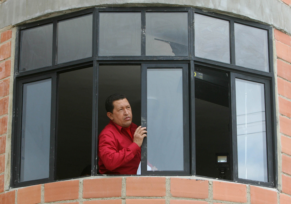 Preşedintele venezuelean Hugo Chavez se uită pe fereastra unuia dintre apartamentele nou inaugurate de guvernul său în Los Naranjillos, statul Lara, duminică 7 mai 2006. 