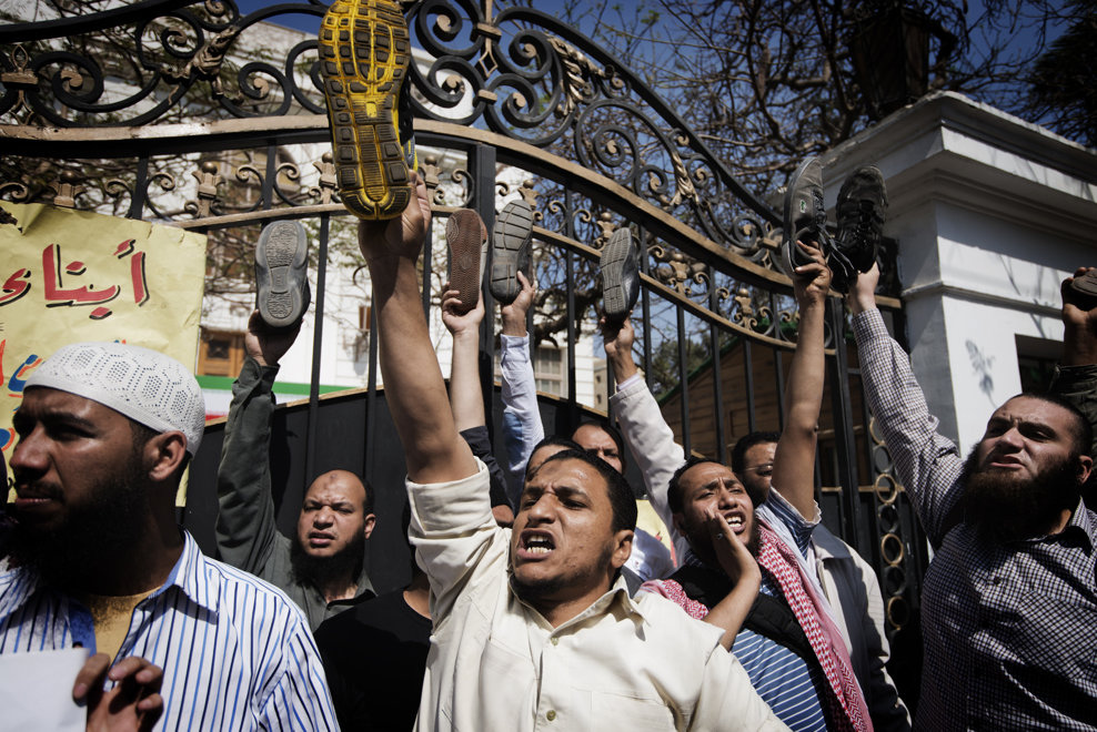 Protestatari egipteni îşi arată încălţările în timp ce scandează sloganuri politice si religioase în faţa reşedinţei amabasadorului Iranului la Cairo, în timpul unei demonstraţii organizate de salafiştii musulmani radicali, în Cairo, vineri, 5 aprilie 2013.