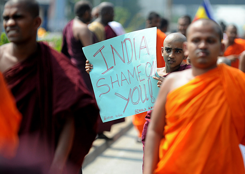 Un grup de budişti Sinhala Rawaya poartă o pancartă pe care scrie ‘India, să-ţi fie ruşine!’ în timp ce se îndreaptă spre sediul Înaltei Comisii Indiene pentru a protesta împotriva atacurilor asupra sri-lankezilor aflaţi în vizită în provincia sudică Tamil Nadu, în Colombo, vineri, 19 martie, 2013.