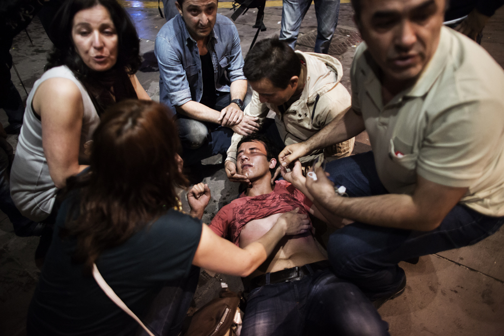 Un protestatar bătut de forţele de ordine este ajutat de mai multe persoane, după confruntările dintre poliţie şi demonstranţi, în Piaţa Kizilay din Ankara, duminică, 9 iunie 2013. 
