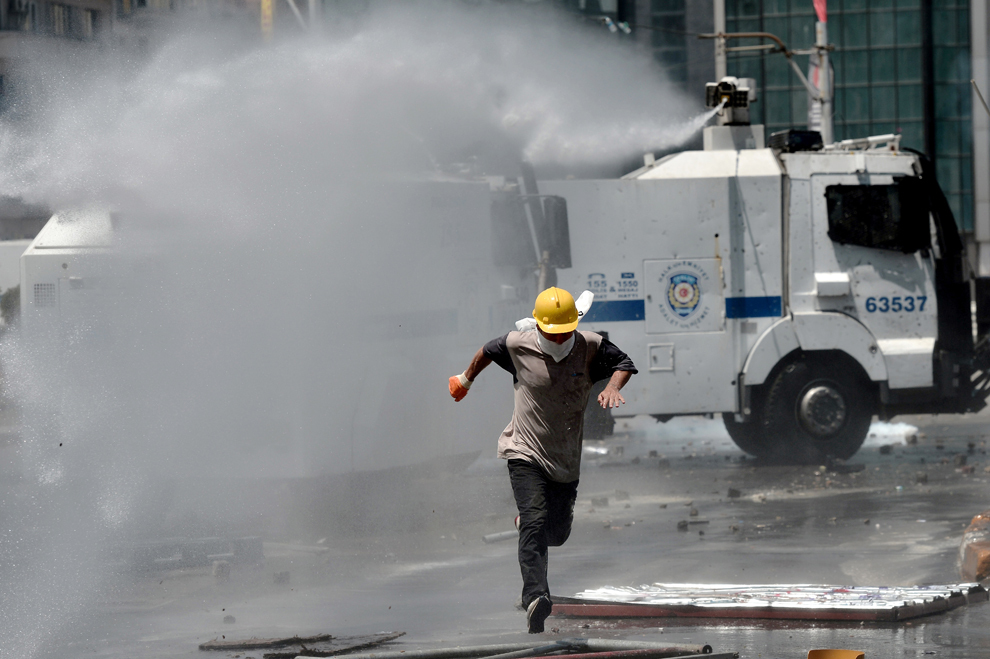 Un protestatar fuge din calea unui tun cu apă, în Piaţa Taksim din Istanbul, marţi, 11 iunie 2013. 