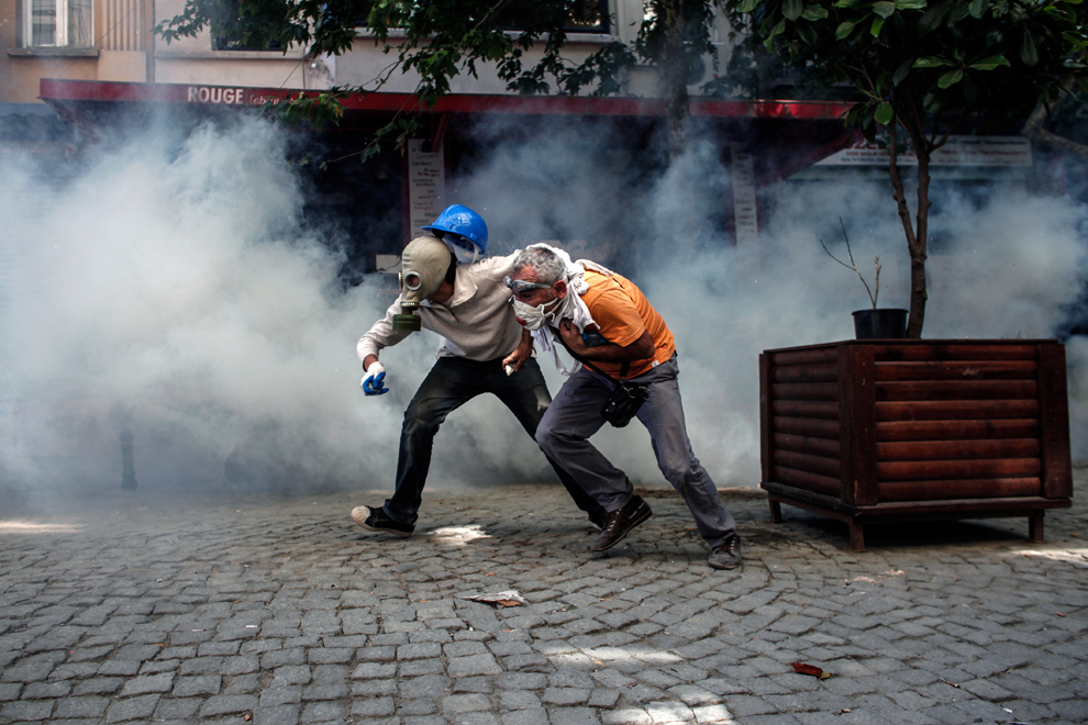 Demonstranţi încearcă să scape de forţele de ordine, în Piaţa Taksim din Istanbul, marţi, 11 iunie 2013. 
