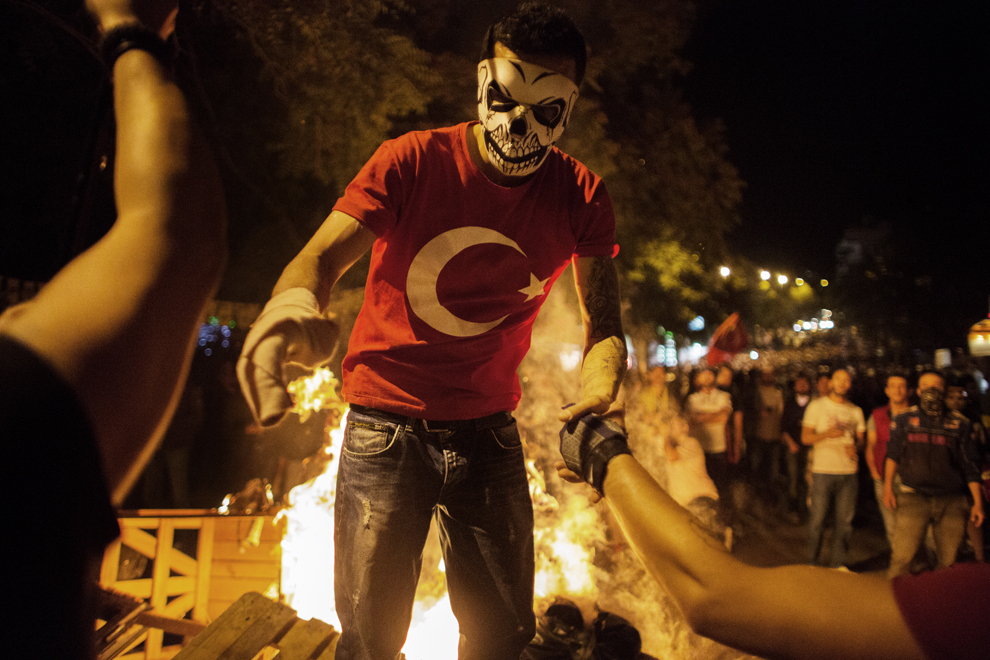 Un protestatar mascat este ajutat de alţi protestatari, în timpul încleştărilor dintre aceştia si poliţie, în centrul capitalei Ankara, miercuri 12 iunie 2013. 