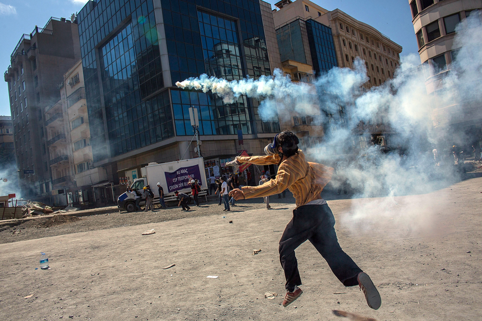 Un protestatar aruncă înapoi un proiectil cu gaz lacrimogen, în timpul încleştărilor cu forţele de ordine, în Piaţa Taksim din Istanbul, marţi, 11 iunie 2013.