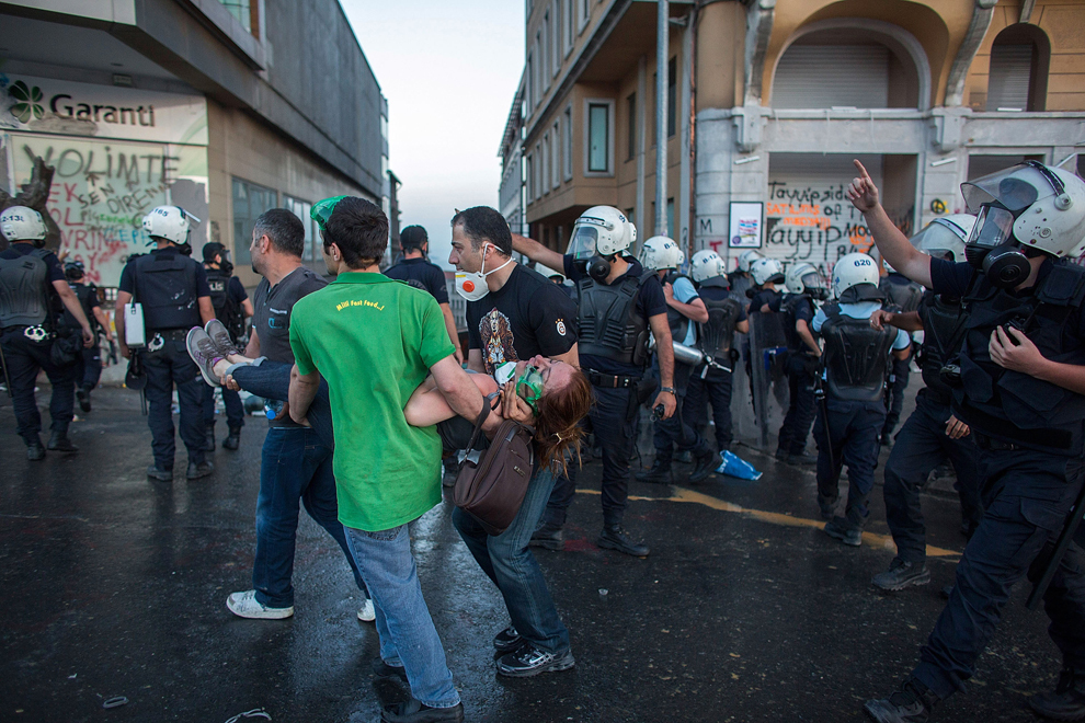 Mai multe persoane transportă o femeie rănită către o ambulanţă, după ce forţele de ordine au folosit gaze lacrimogene împotriva demonstranţilor din Piaţa Taksim, în Istanbul, marţi, 11 iunie 2013. 