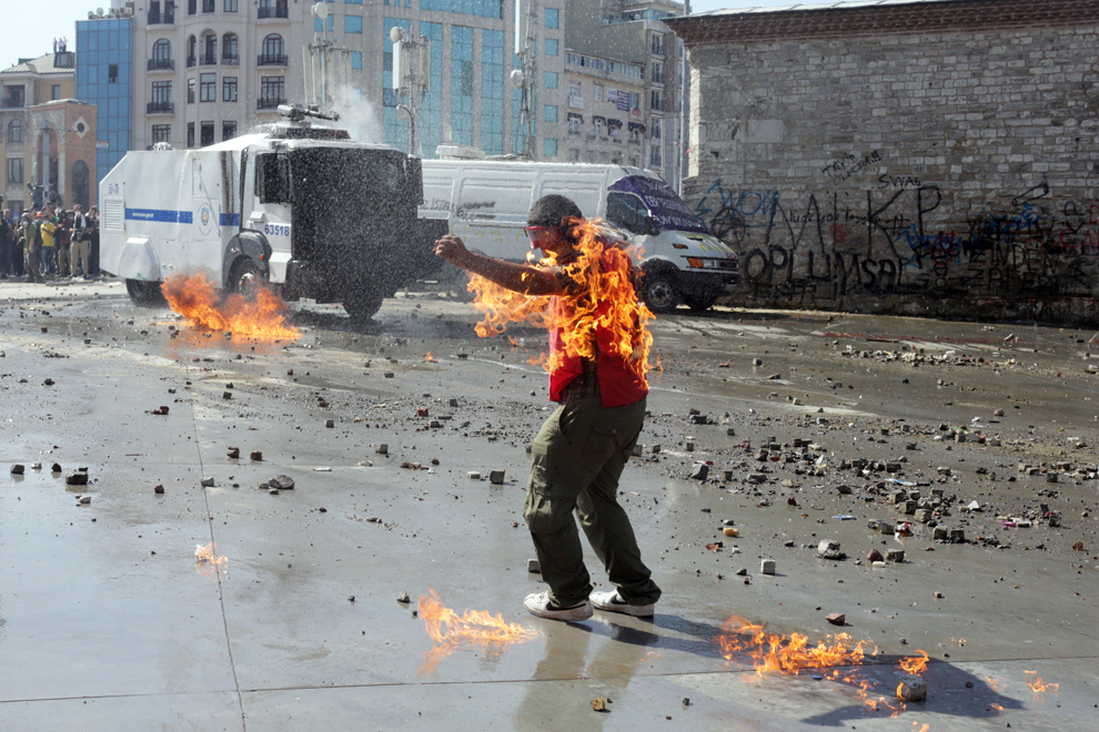 Hainele unui protestatar sunt în flăcări, în timpul ciocnirilor dintre forţele de ordine şi manifestanţi, în Piaţa Taksim din Istanbul, marţi, 11 iunie 2013. 