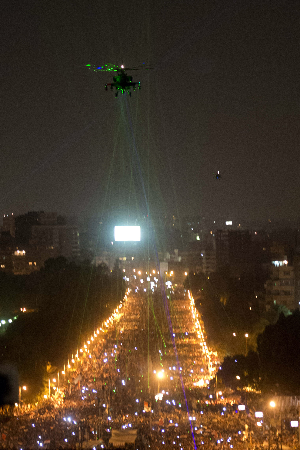 Protestatari egipteni luminează cu lasere un elicopter militar ce survolează palatul prezidenţial, în Cairo, Egipt, duminică, 30 iunie 2013. 
