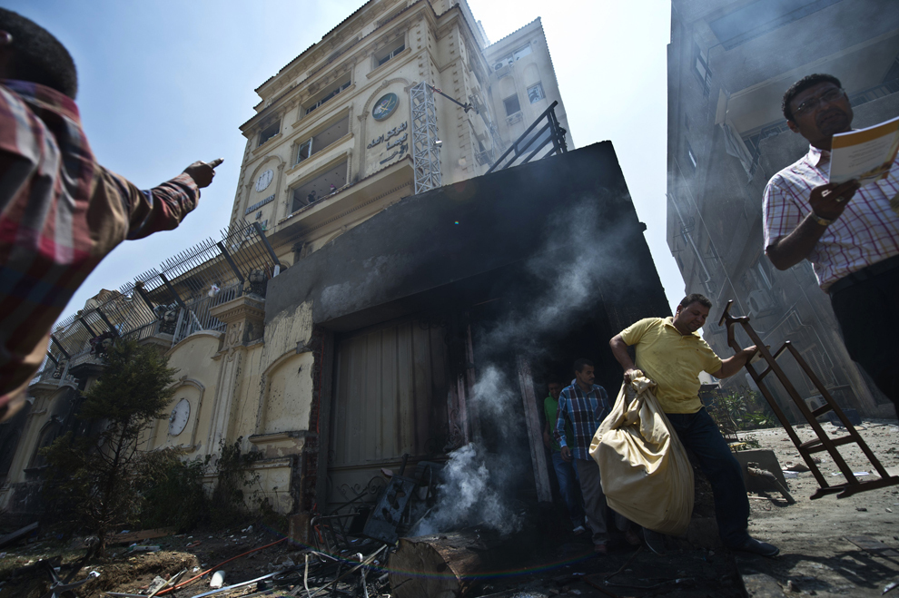 Egipteni transportă bunuri furate din sediul incendiat al Fraţiei Musulmane (Muslim Brotherhood), în districtul Moqattam din Cairo, Egipt, luni, 1 iulie 2013. 