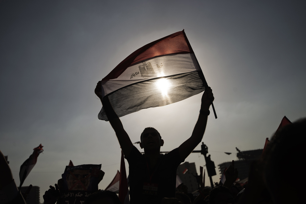 Un protestatar flutură steagul naţional al Egiptului, în timp ce sute de mii de oameni sărbătoresc ultimatumul dat de armată preşedintelui Mohamed Morsi, în piaţa Tahrir din Cairo, Egipt, luni, 1 iulie 2013. 