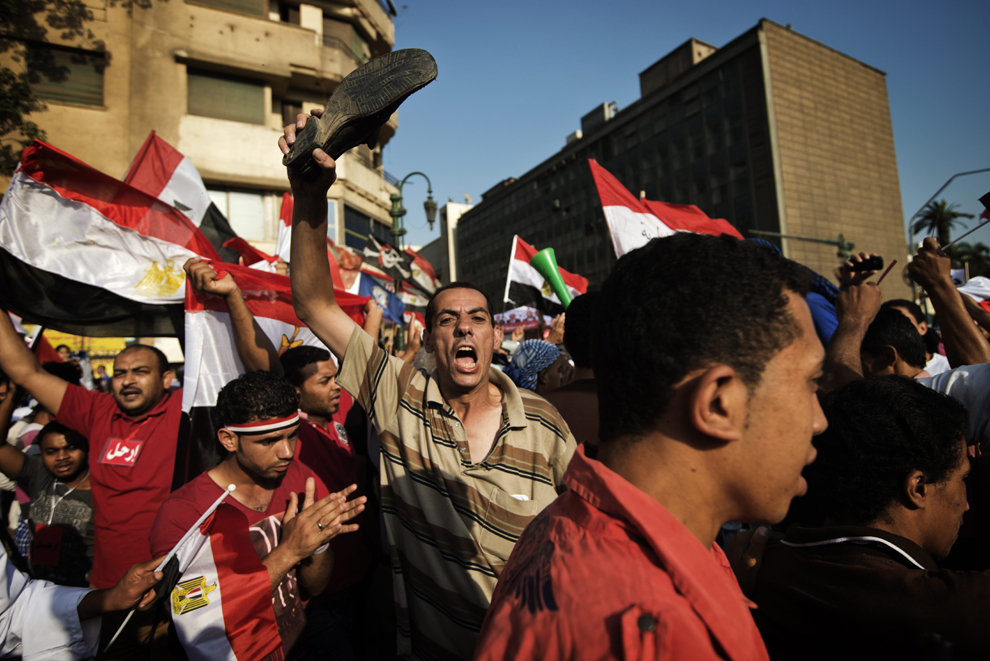 Un protestatar ţine în mână un pantof, în timp ce sute de mii de oameni sărbătoresc ultimatumul dat de armată preşedintelui Mohamed Morsi, în piaţa Tahrir din Cairo, Egipt, luni, 1 iulie 2013. 