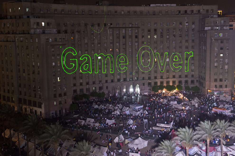Suporteri ai opoziţiei egiptene se strâng în piaţa Tahrir din Cairo, în timp ce lumini laser îndreptate spre clădirea guvernului  arată mesajul “ Game Over” , marţi, 2 iulie 2013. 