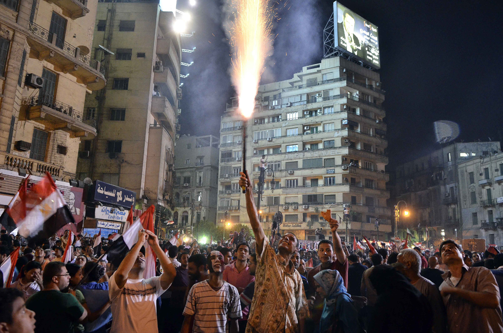 Un protestatar aprinde o torţă, în timp ce sute de mii de oameni sărbătoresc ultimatumul dat de armată preşedintelui Mohamed Morsi, în piaţa Tahrir din Cairo, Egipt, luni, 1 iulie 2013. 