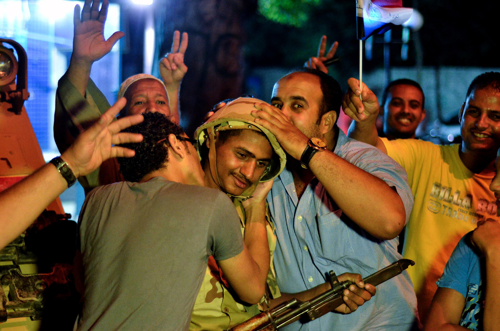 Persoane îmbrăţişează şi sărută un soldat din armata egipteană, după confirmarea zvonurilor de preluare temporară a puterii de către armată de la primul preşedinte  ales democratic, Mohammed Morsi, în piaţa Tahrir din Cairo, Egipt, miercuri, 3 iulie 2013. 