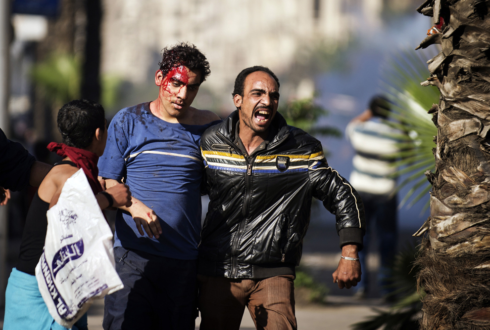 Un egiptean rănit, ce a fost atacat de către membri ai Frăţiei Musulmane (Muslim Brotherhood), este ajutat în timpul luptelor de stradă între suporterii şi oponenţii partidului de conducere, în centrul oraşului Cairo, Egipt, vineri, 19 aprilie 2013. 