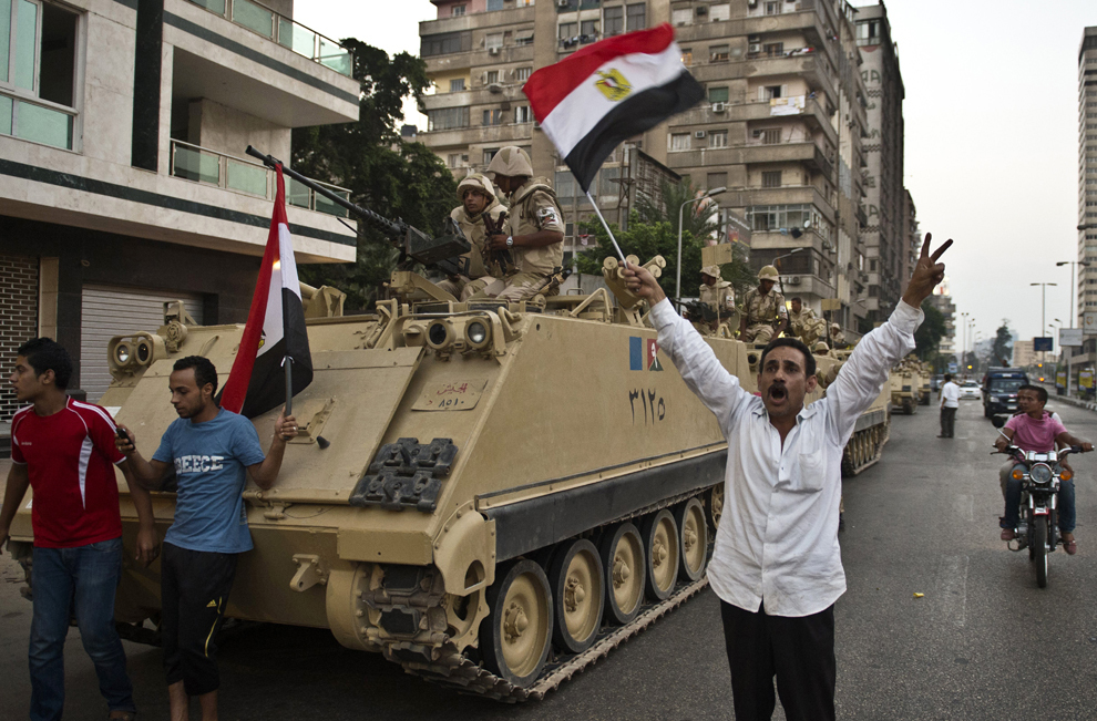 Egipteni salută tancurile armatei în timpul unei desfăşurări de forţe, în Cairo, Egipt, miercuri, 3 iulie 2013. 