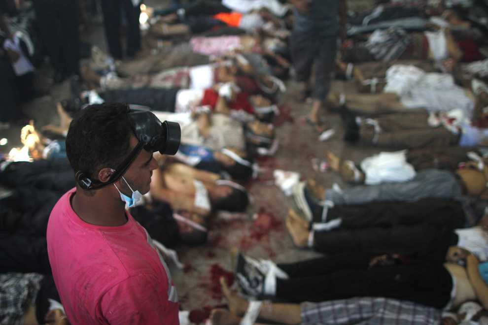 Un barbat priveşte către cadavre aşezate într-o morgă improvizată, după ce poliţia egipteană a dispersat susţinatorii fostului preşedinte Mohamed Morsi din doua tabere din Cairo, miercuri, 14 august 2013. 