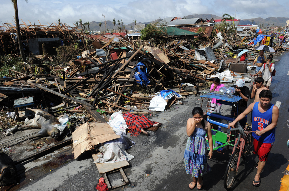 Localnici afectaţi de super-taifunul Haiyan trec pe lângă rămaşiţele caselor distruse, pe un drum din Tacloban,  provincia Leyte, Filipine, duminică, 10 noiembrie 2013. 