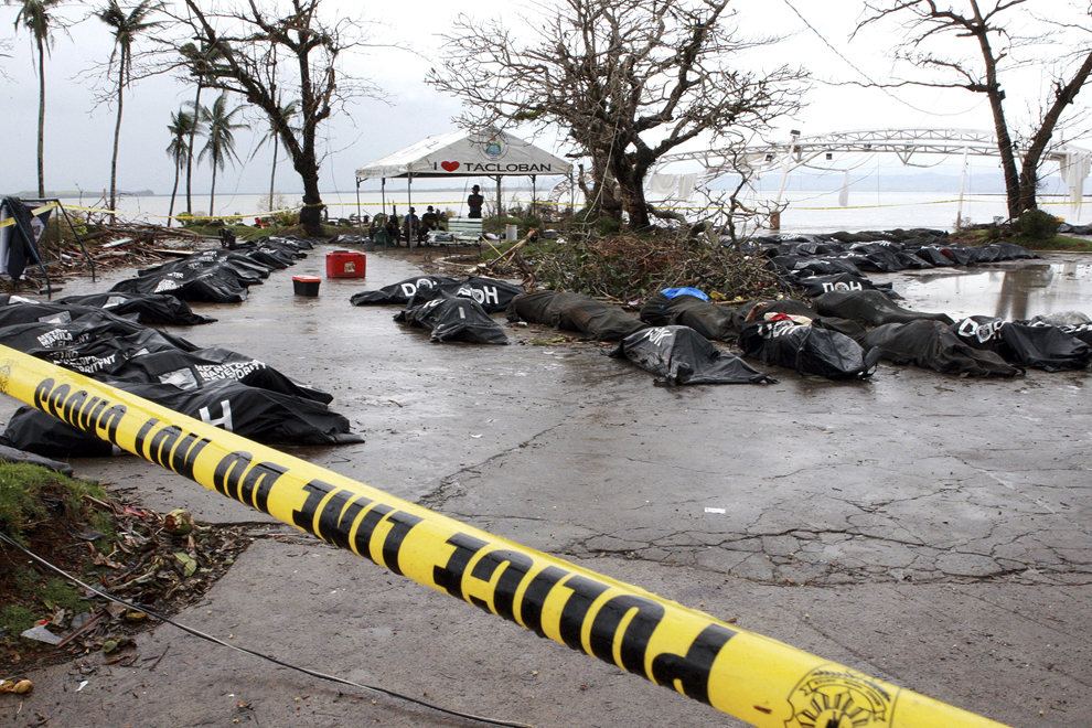 Saci cu corpurile persoanelor decedate în taifunul Haiyan şi recuperate de armată, sunt aşezaţi pe pământ, în apropiere de Tacloban, provincia Leyte, Filipine, marţi, 12 noiembrie 2013. 