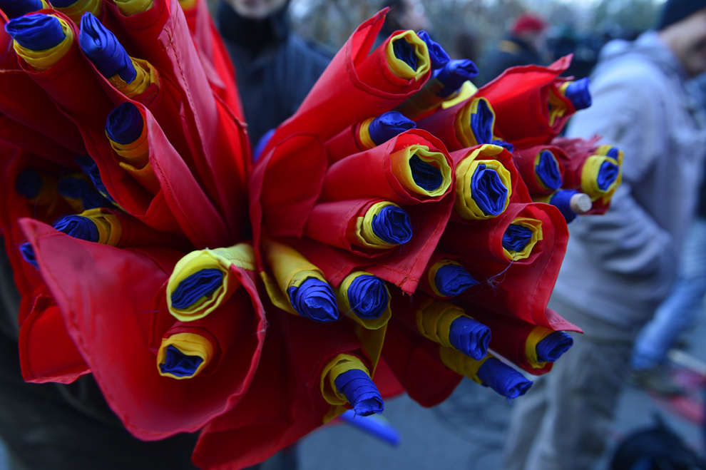O persoană ţine în braţe mai multe drapele naţionale, de "Ziua Porţilor Deschise la Palatul Victoria", eveniment organizat cu prilejul Zilei Naţionale a României, în Bucureşti, duminică, 1 decembrie 2013.