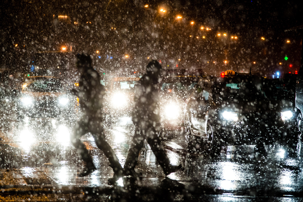 Persoane traversează strada, în timpul unei ninsori, în Bucureşti, marţi, 26 noiembrie 2013.