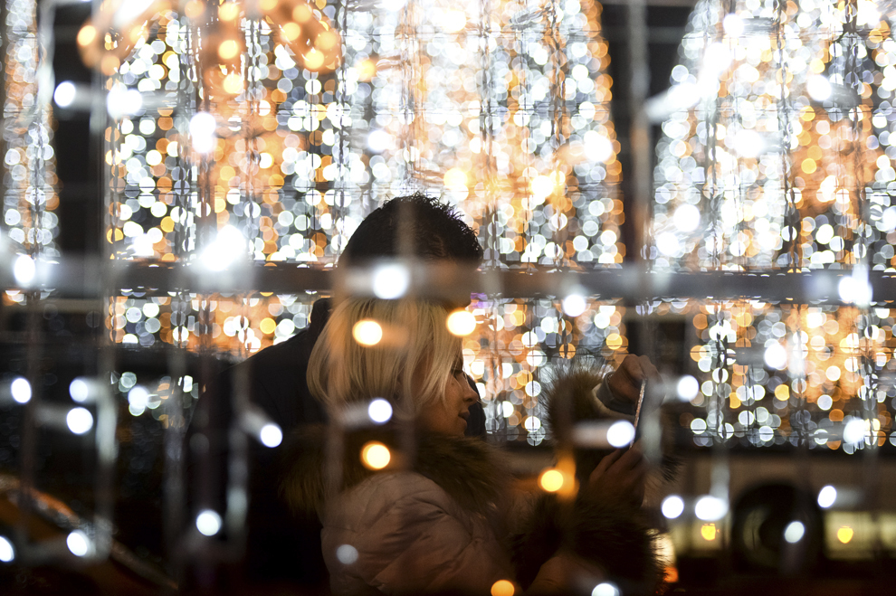 Doi tineri se fotografiază cu luminiţele de sărbători, în Piaţa Romană din Bucureşti, vineri, 6 decembrie 2013.