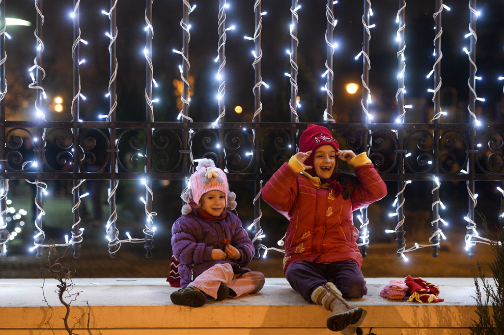 Doi copii se joacă, lângă  instalaţiile de iluminat, montate în parcul "Alexandru Ioan Cuza" din Sectorul 3, în Bucureşti, duminică, 1 decembrie 2013.