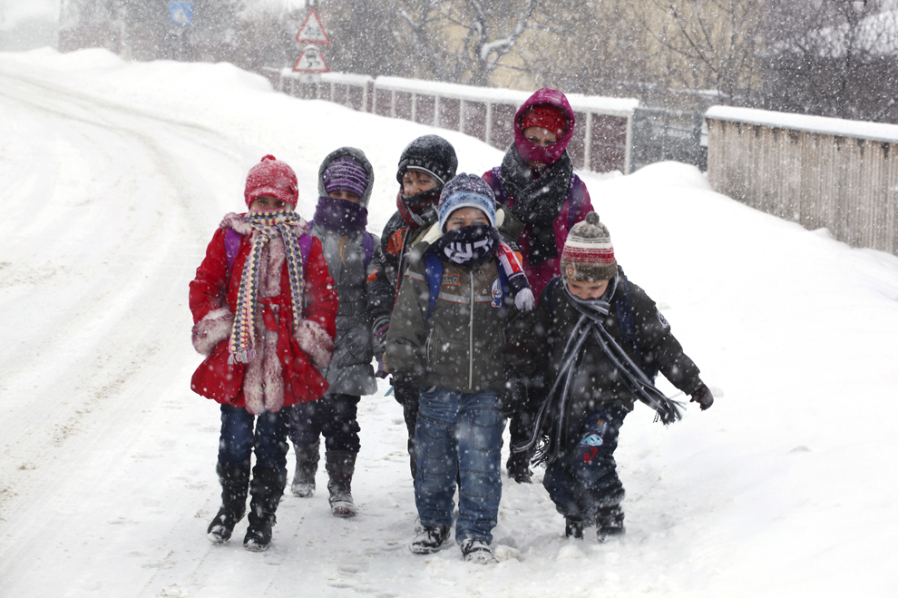 Copii merg prin ninsoare, pe DN 24B, în localitatea Cozia (30 km distanţă de Iaşi), vineri, 25 ianuarie 2013.