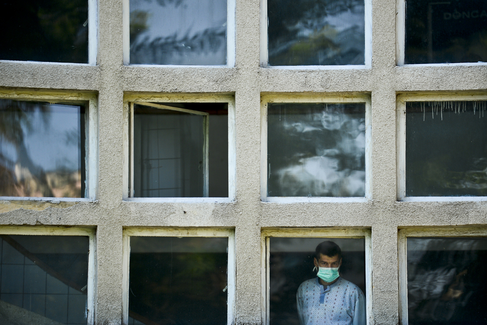 Un pacient, cu o mască pe faţă, priveşte de la geamul unei secţii a Institutului de Pneumoftiziologie "Marius Nasta" desfăşurarea unei conferinţe de presă în care este anunţat primul proiect de colectare a inhalatoarelor folosite, organizate de GlaxoSmithKline, în Bucureşti, luni, 2 septembrie 2013.