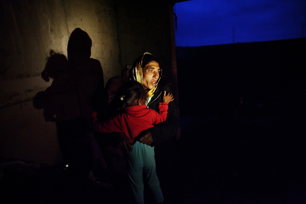 O femeie de etnie roma îşi îmbracă copilul, într-o clădire aflată în construcţie, în Eforie Sud, sâmbătă, 29 septembrie 2013. Peste 100 de locuitori ai cartierului de romi din Eforie Sud, dintre care 55 sunt copii, locuiesc în adăposturi improvizate, după ce Primaria a decis, în 27 septembrie, să demoleze cele 22 de case şi barăci în care aceştia locuiau.