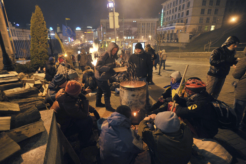 Opozanţi ai guvernului se încălzesc la primele ore ale dimineţii într-o tabară de corturi ridicată în Piaţa Independenţei din Kiev, miercuri, 4 decembrie 2013.