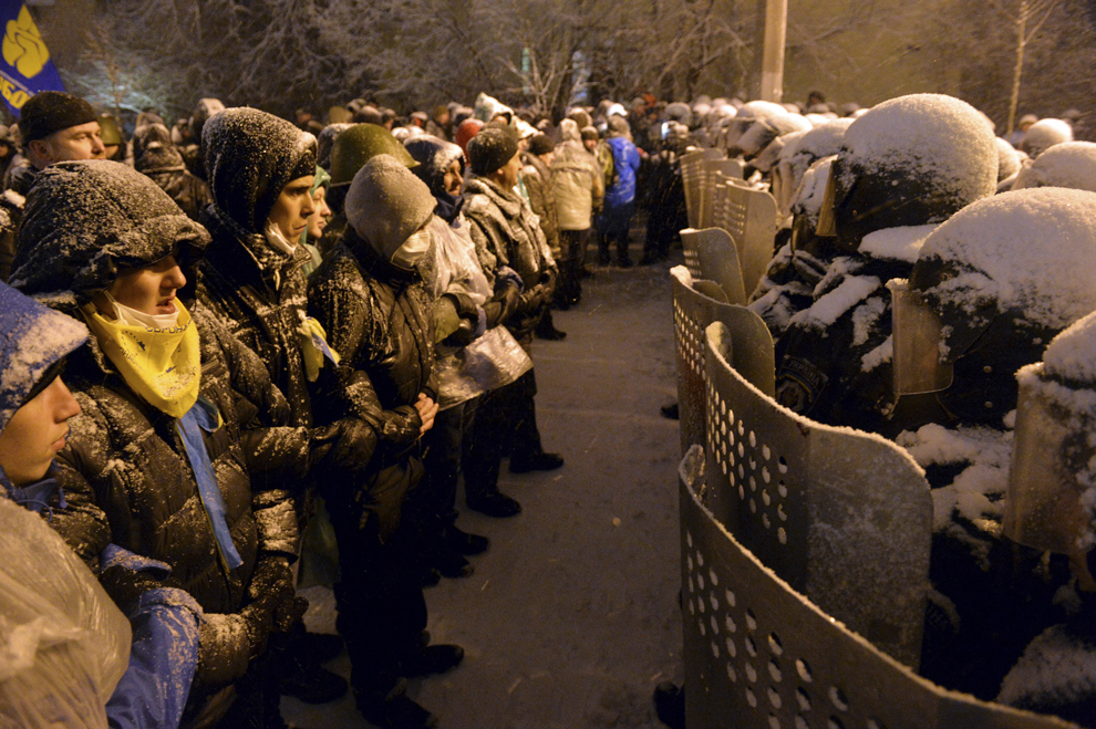 Protestatari ucrainieni Pro-UE privesc forţele de ordine ce păzesc zona ce înconjoară palatul prezidenţial, în Kiev, luni, 9 decembrie 2013.