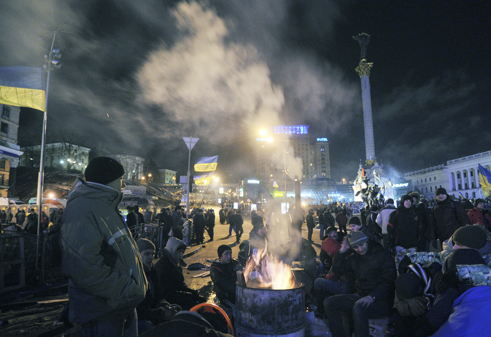 Protestatari ucrainieni se încălzesc lângă foc, în Piaţa Independenţei din Kiev, sâmbătă , 14 decembrie 2013.