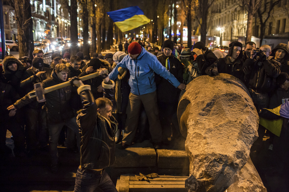 Un protestatar distruge statuia lui Lenin, în timpul unui miting de protest denumit "Marşul Milioanelor", în piaţa Independenţei din Kiev, duminică, 8 decembrie 2013.